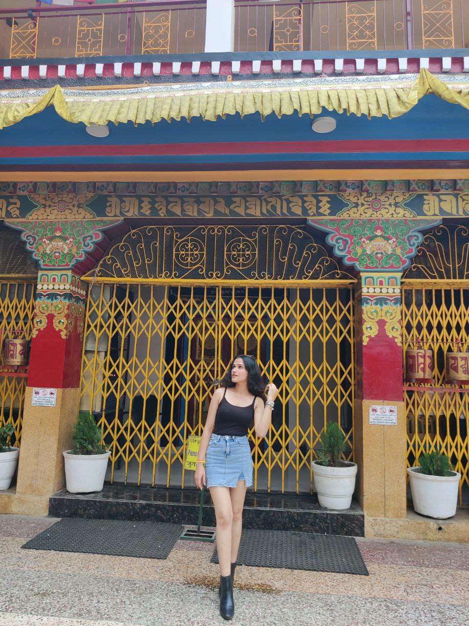 Shakshi in a denim skirt and black cami outside a monastery on her Rishikesh trip